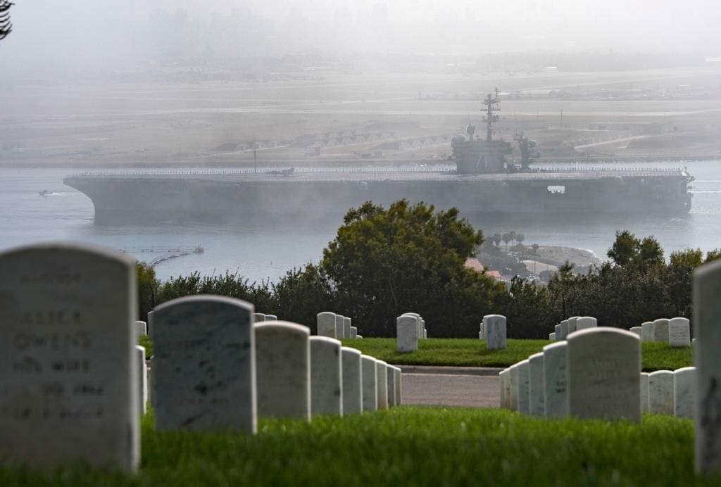 photo of US Navy ship in the background of an american military cemetery